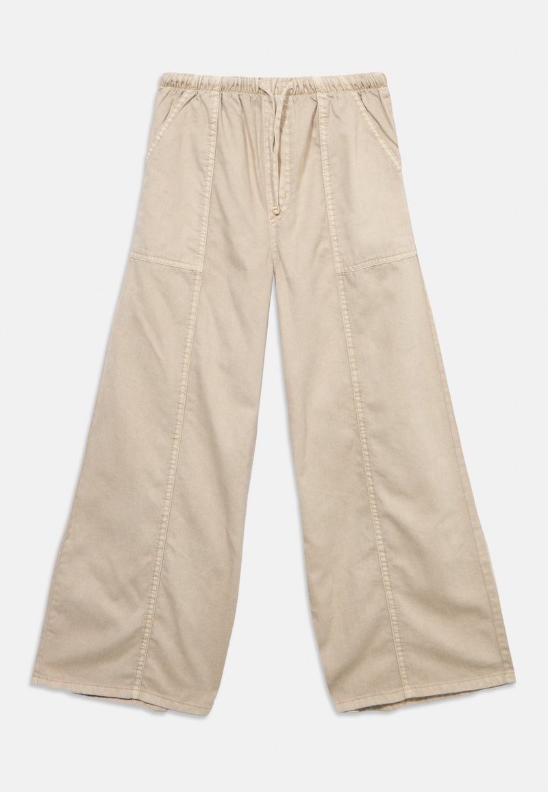 Beige Hosen mit weitem Bein, elastischem Bund, Seitentaschen und sichtbaren Nahtdetails an Vorderseite und Beinen.