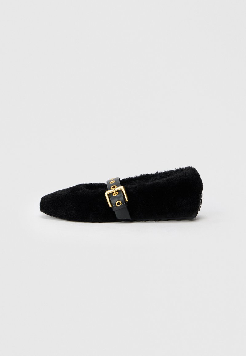Schwarzer Flachschuh mit flauschiger Textur, spitzem Zeh und einem goldenen Schnallenakzent an einem schwarzen Riemen. Verfügt über einen niedrigen Absatz und eine weiche Innensohle.