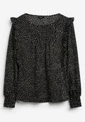 Schwarze Bluse mit einem weiß gesprenkelten Muster, langen Ärmeln, geraffter Textur und Rüschendetails an den Schultern. Gummierte Manschetten.