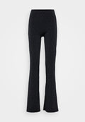 Schwarze, ausgestellte Hose mit einem dehnbaren Bund, verziert mit verstreuten silbernen Metallic-Punkten. Hergestellt aus einem glatten, weichen Stoff.