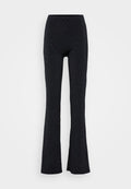 Schwarze, ausgestellte Hose mit einem dehnbaren Bund, verziert mit verstreuten silbernen Metallic-Punkten. Hergestellt aus einem glatten, weichen Stoff.
