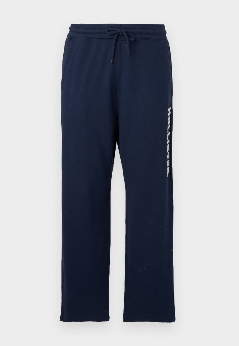 Marineblaue Sweatpants mit elastischem Bund und Kordelzug, geraden Beinen und "Hollister" senkrecht auf der rechten Seite aufgedruckt.