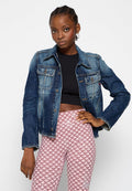 Dunkelblaue Jeansjacke im klassischen Schnitt, mit zwei Fronttaschen, Knopfverschluss und verblassten Details, kombiniert mit gemusterten rosa Leggings.