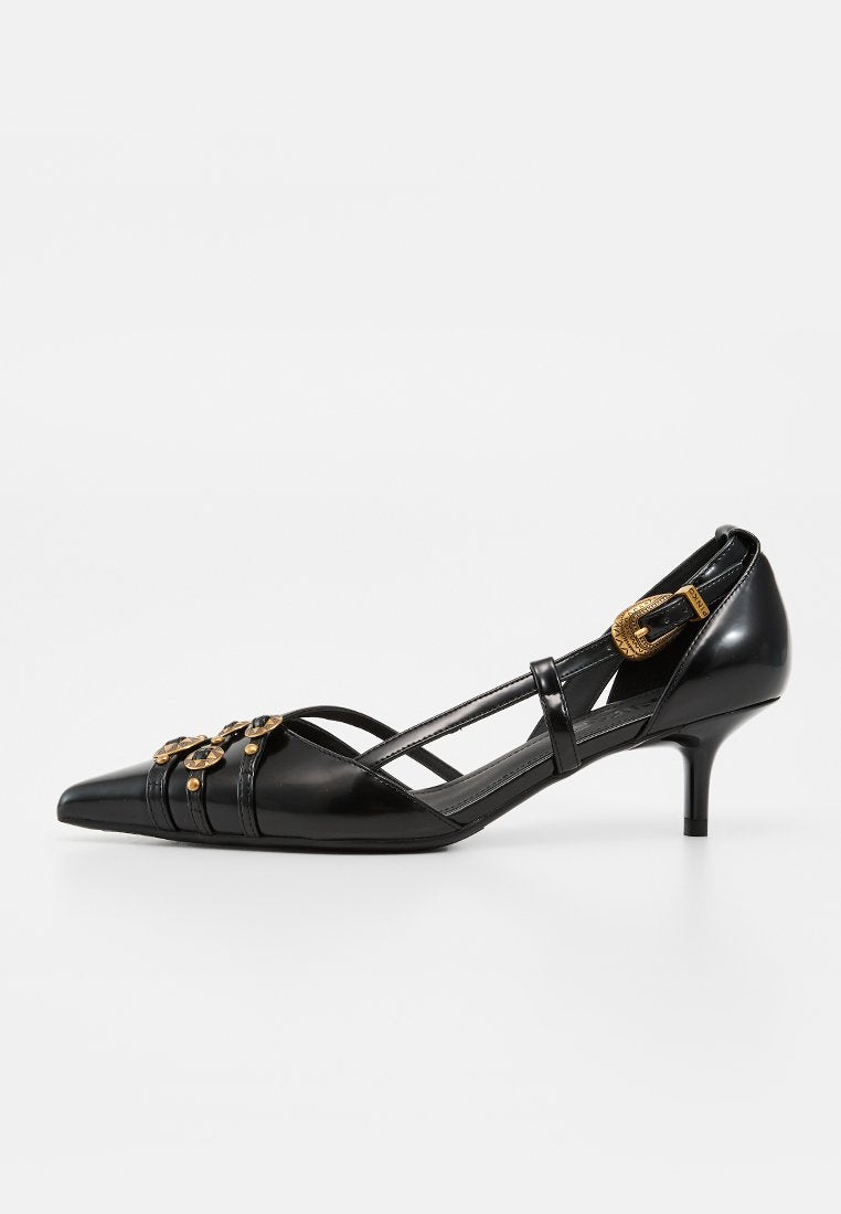 Schwarzer Leder-Pumps mit spitzer Kappe, niedrigem Absatz, goldenen dekorativen Schnallen und einem dünnen Riemen über dem Spann.