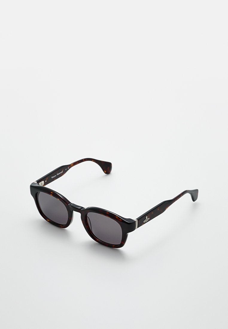 Schildpatt-Sonnenbrille mit dunklen Gläsern, rechteckiger Form, dicken Rahmen und metallischen Akzenten an den Bügeln.