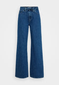 Hochtaillierte blaue Jeans mit weitem Bein, vorderen Taschen, Gürtelschlaufen und einem gebundenen Stoffgürtel an der Taille vor einem schlichten Hintergrund.