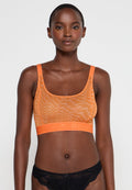 Oranger Mesh-Bralette mit U-Boot-Ausschnitt, ausgestattet mit einem Branding-Muster und einem elastischen Logo-Bund. Glatte Textur, lässiges Design.