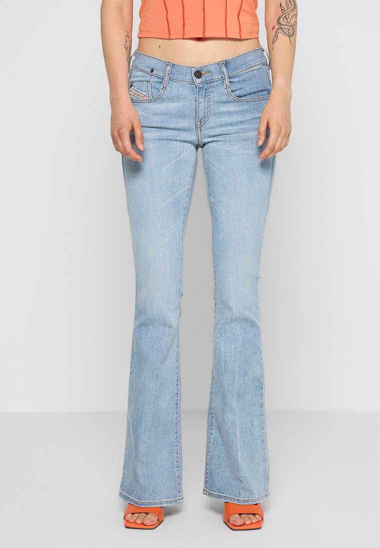 Hellblaue Schlagjeans aus Denim-Stoff mit mittelhohem Bund, ausgestattet mit dezenten Nähdetails und vorderen Taschen.