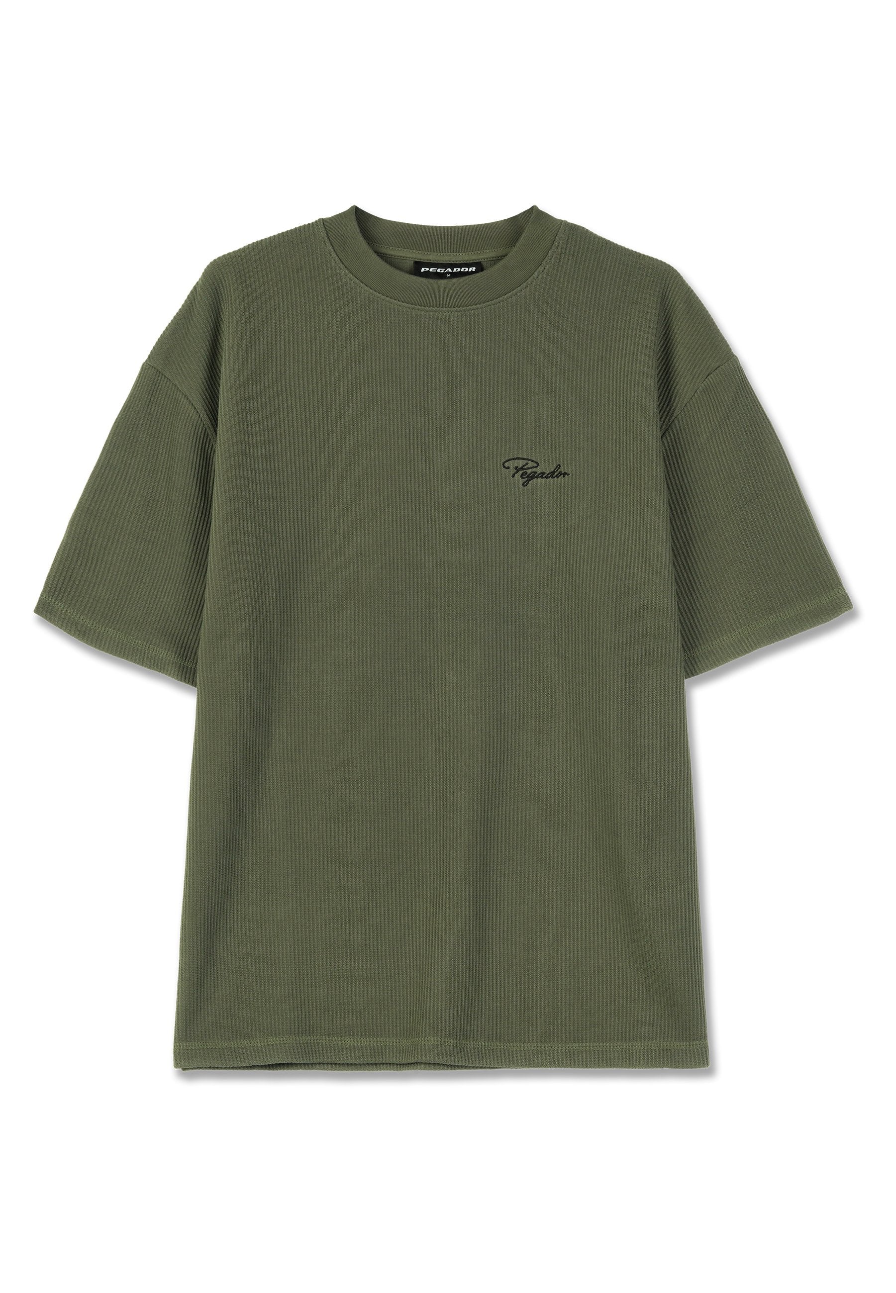 Olivgrünes, geripptes T-Shirt mit kurzen Ärmeln, rundem Hals und einem kleinen schwarzen Logo, das auf der linken Brust gestickt ist. Weiche Stofftextur.