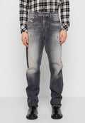 Graue Denim-Jeans mit einem ausgebleichten Finish, im entspannten Schnitt, mit dezentem Verblassen und abgenutzten Details. Getragen mit schwarzen Schuhen.