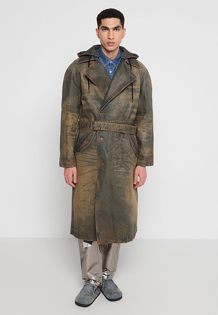Langer, weit geschnittene Trenchcoat aus gewaschenem Olivenstoff mit einem taillierten Gürtel, großem Kragen und sichtbaren Nähten.