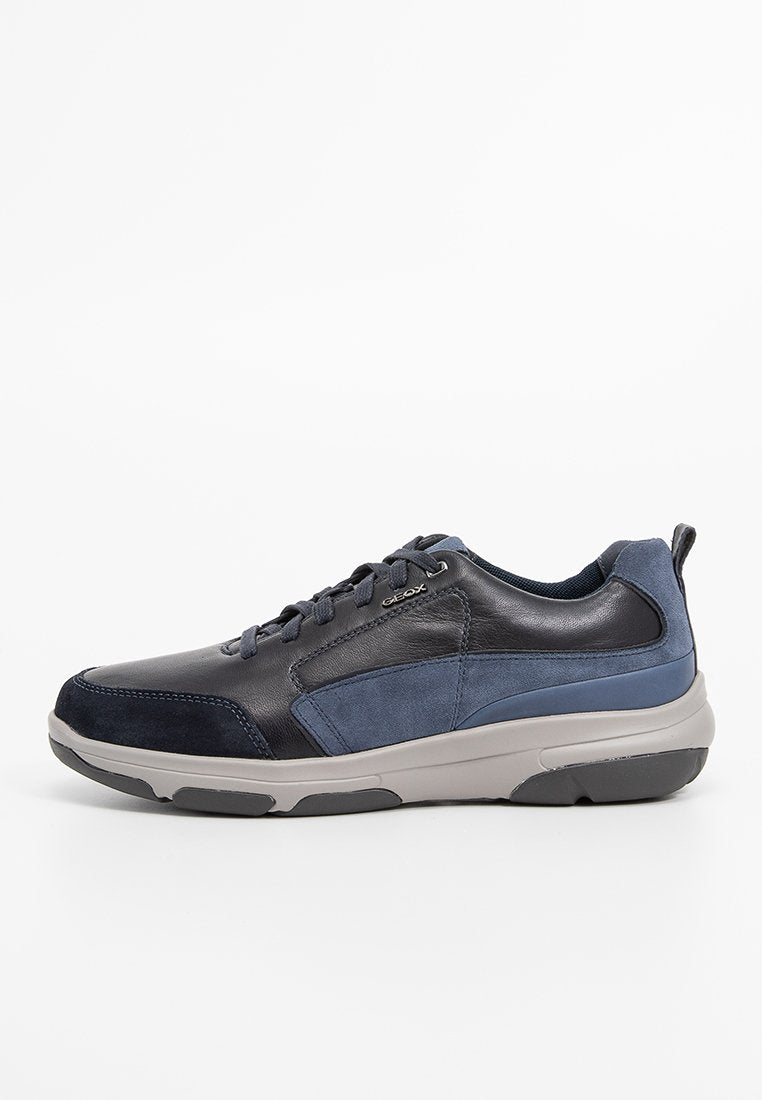 Herren Sneaker aus dunkelblauem Leder und Wildleder, mit einer grauen Gummisohle, Schnürdesign und minimaler Markenanpassung.