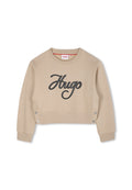 Beige, verkürzter Sweatshirt aus weichem Stoff, mit schwarzem, gesticktem "Hugo"-Logo und silbernen Knopfakzenten an den Seiten.