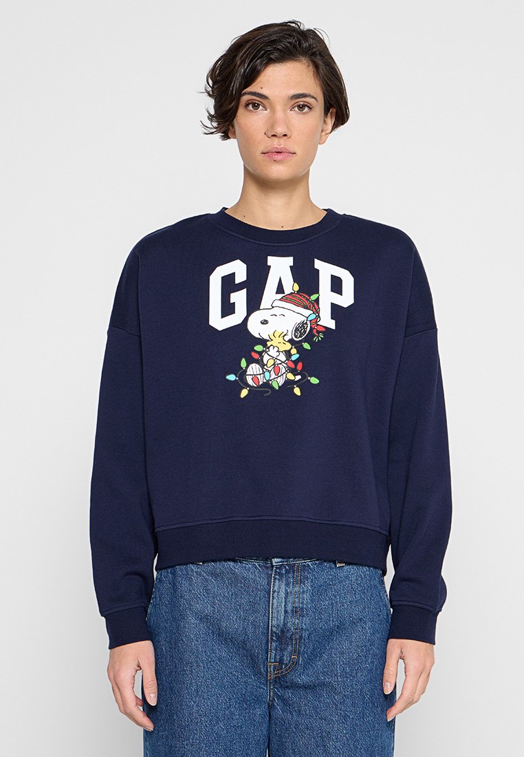 Marineblauer Sweatshirt mit weißem "GAP"-Logo und einem bunten Snoopy-Design mit Weihnachtslichtern. Lockerer Schnitt, gerippte Bündchen und Saum.