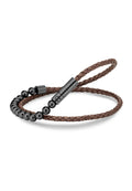Braunes geflochtenes Lederarmband mit schwarzen Metallperlen und einem eleganten schwarzen Verschluss. Texturiertes Design mit abwechselnden Perlengrößen.
