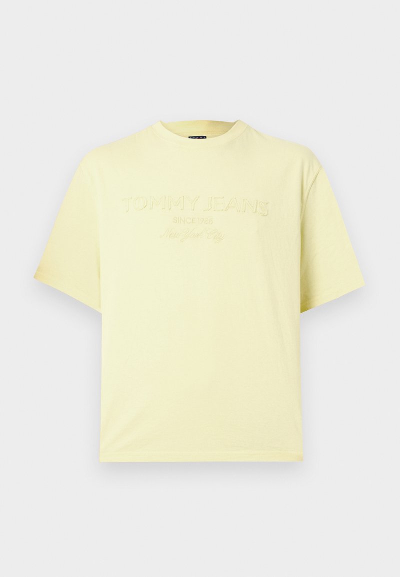 Helles gelbes kurzärmliges Baumwoll-T-Shirt mit erhabenem Text "Tommy Jeans Since 1985 New York City" auf der Brust.