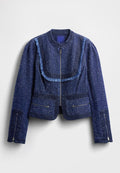Dunkelblaue Jeansjacke mit strukturierter Stoffqualität, Fransen entlang des Kragens, Reißverschluss vorne und zwei Fronttaschen mit Reißverschlüssen.