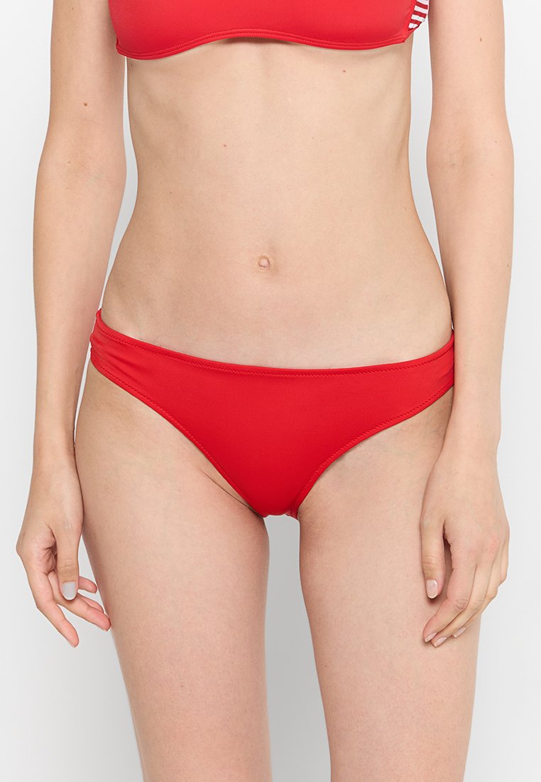 Rote Bikinihosen aus glattem, dehnbarem Stoff. Sie haben einen tiefer geschnittenen Bund mit einfacher Naht und einem einfarbigen Design.