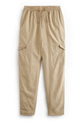 Beige Cargo-Hosen mit einem elastischen Bund, Kordelzug und zwei großen Seitentaschen. Glattes Material mit lockerem Schnitt und schmal zulaufendem Bein.