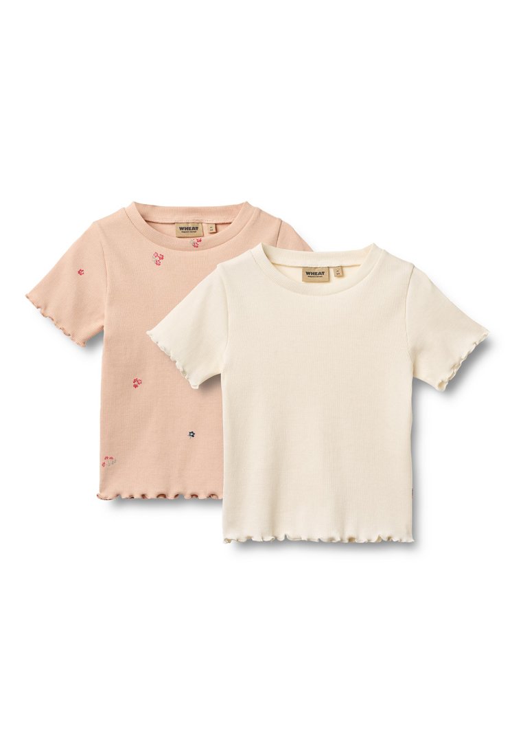 Zwei kurzärmelige T-Shirts: eines pink mit Blumenstickerei, das andere weiß, beide mit gerippter Textur und gewellten Säumen.