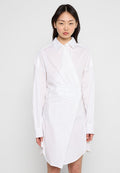 Weißes Hemdkleid mit strukturiertem Design, das eine diagonale Überlappung und ein kreisförmiges Logodetail auf der Vorderseite aufweist. Lange Ärmel mit Manschetten.