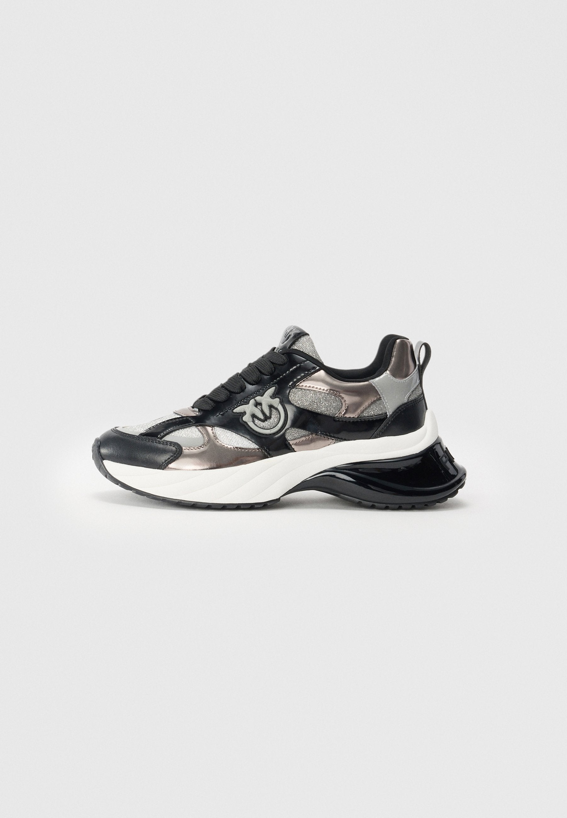 Schwarze und silberne chunky Sneaker mit dicker weißer Sohle, strukturiertem Stoff, schwarzen Schnürsenkeln und einer Schlaufe zum Einziehen an der Ferse.
