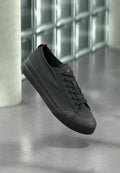 Schwarze Leinwand-Sneaker mit Gummisohle, runder Zehenpartie und Schnürdesign. Verfügt über ein kleines rotes Logo auf der Zunge und seitliche Nahtdetails.