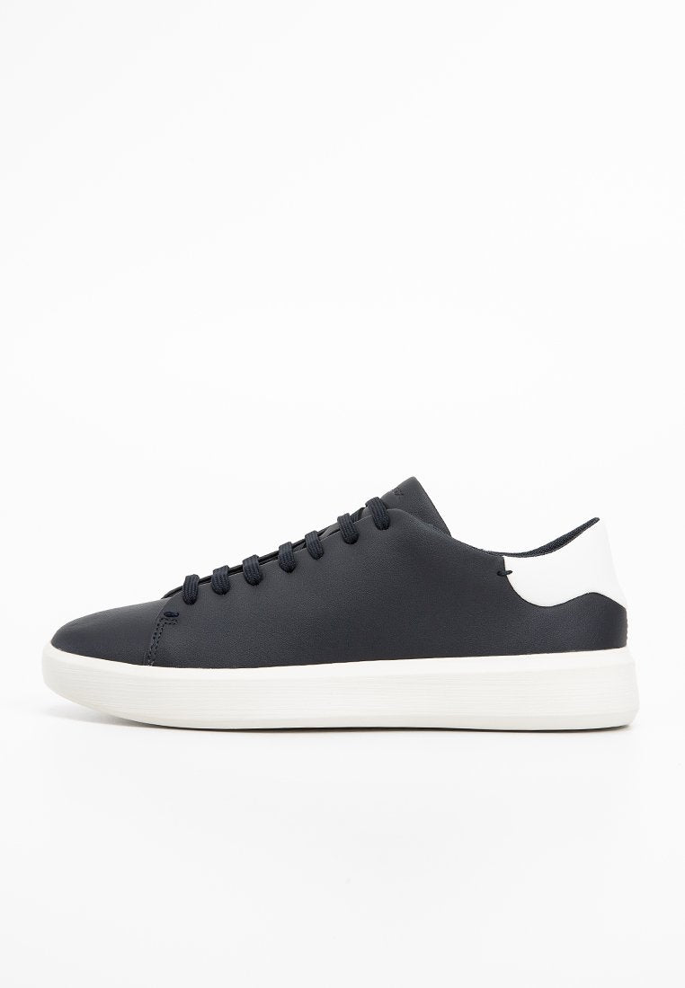 Schwarze Ledersneaker mit weißen Akzenten, flache Sohle, runde Zehenform und sechs Paar Ösen für Schnürsenkel. Glatte Textur, minimalistisches Design.