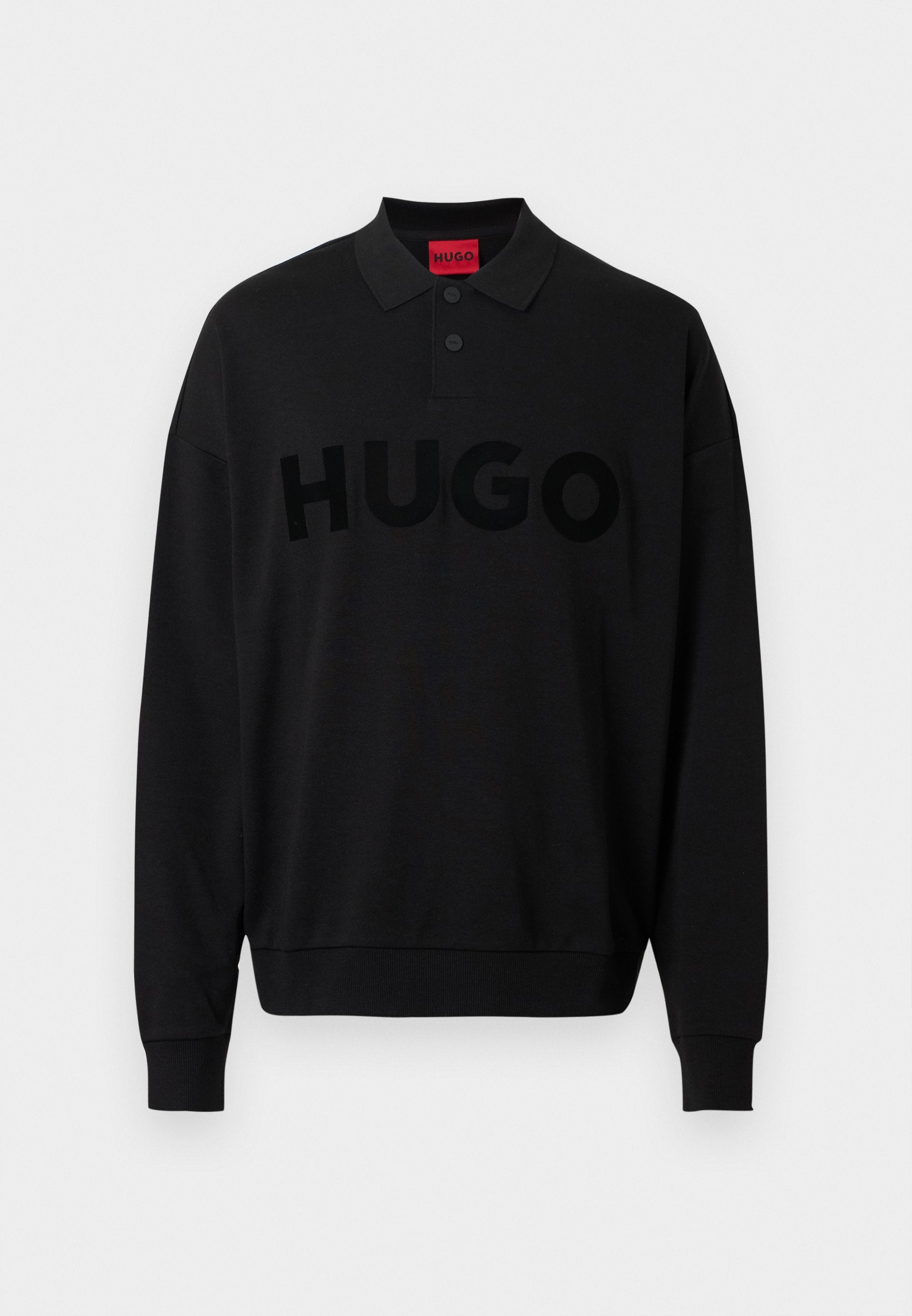 Schwarzes langärmliges Polohemd mit geripptem Kragen, das ein auffälliges, strukturiertes "HUGO"-Logo auf der Vorderseite zeigt. Weiches Material, entspannte Passform.