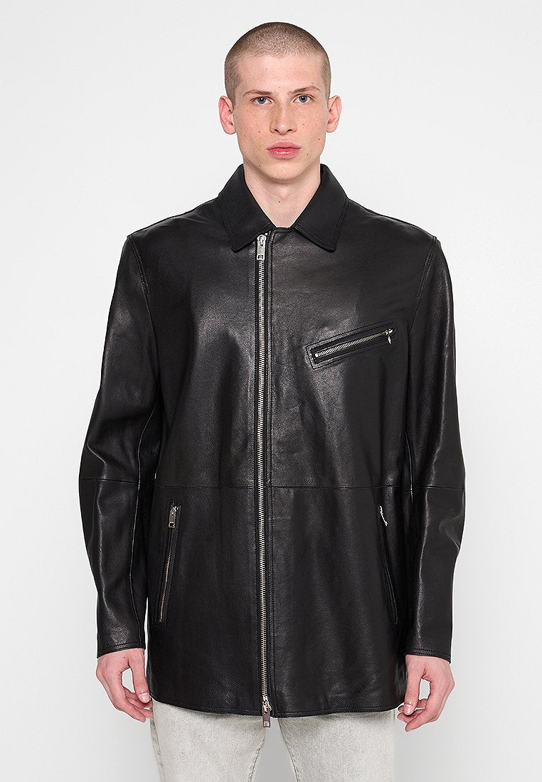 Schwarze Lederjacke mit Reißverschluss vorne, spitzem Kragen, langen Ärmeln und zwei seitlichen Taschen. Verfügt über eine kleine Reißverschlusstasche auf der Brust.