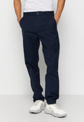 Navy Baumwoll-Chinos mit geradem Bein, Knopfverschluss und Seitentaschen, kombiniert mit hellen Sneakers.