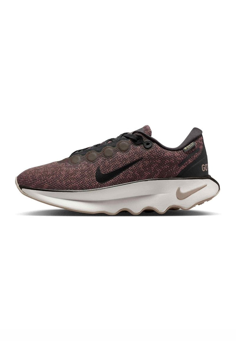 Sportsschuh mit einem schwarzen und kastanienbraunen strukturierten Strickobermaterial, prominenten schwarzen Nike-Swoosh, runden Akzenten und einer weißen gewellten Zwischensohle.