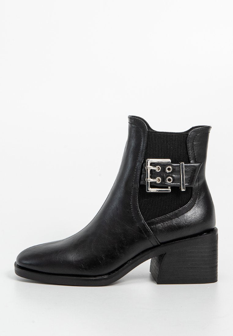 Schwarze Leder-Stiefelette mit runder Zehenform, elastischen Seitenpaneelen und einem silbernen Schnallen-Detail. Verfügt über einen gestapelten Absatz und eine glatte Textur.