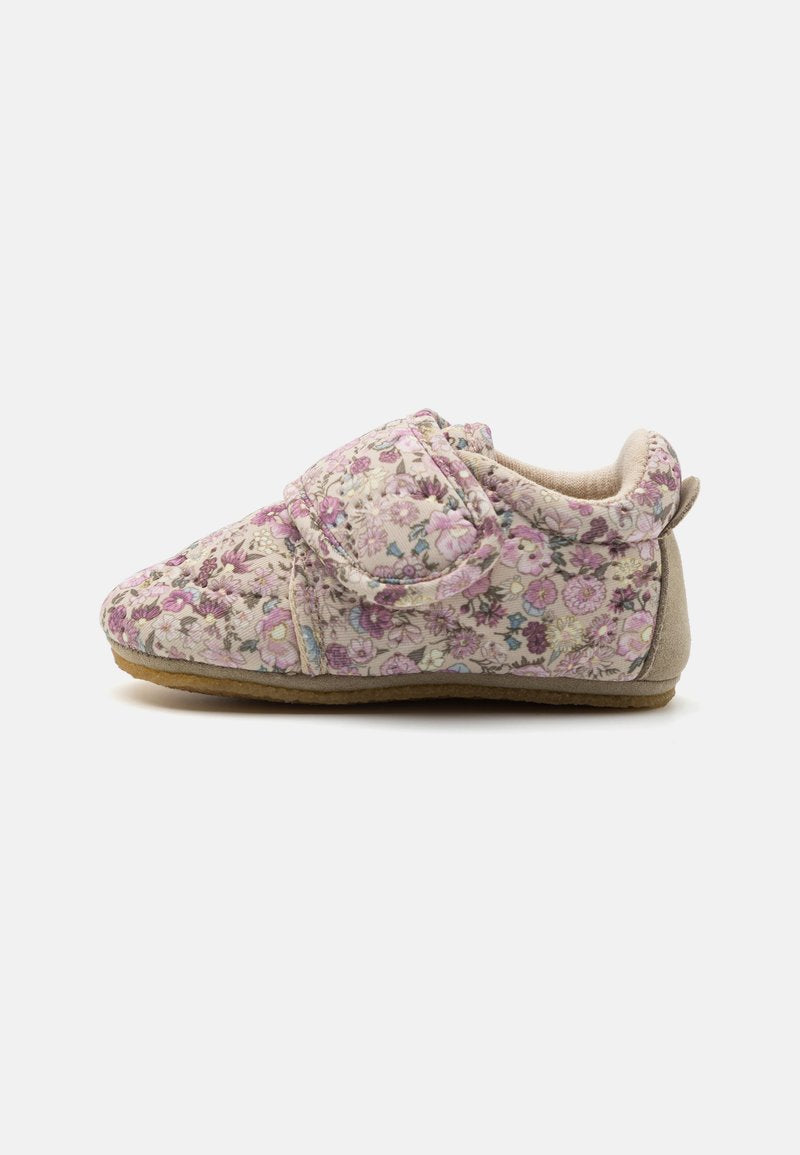 Weiche Babyschuh mit pinkem und lila Blumenmuster, gepolstertem Knöchel und breitem, verstellbarem Klettverschluss auf einem neutralen Hintergrund.