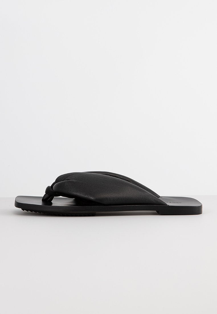 Schwarze Flip-Flop-Sandalen aus Leder mit einem weichen, geknoteten Oberriemen und flacher Gummisohle. Strukturiertes Grippmuster auf der Sohle.