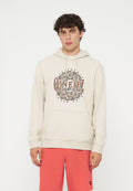 Junger Mann mit lockigem Haar, der einen beigen O'Neill Hoodie und korallenfarbene Shorts trägt, steht vor einem einfarbigen weißen Hintergrund.