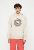Junger Mann mit lockigem Haar, der einen beigen O'Neill Hoodie und korallenfarbene Shorts trägt, steht vor einem einfarbigen weißen Hintergrund.