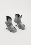 Graue Denim-Ankle-Boots mit fransigem Rand, schwarzem Fleece-Futter und glänzenden silbernen Absätzen. Einzigartiges Design mit gefaltetem Kragen und strukturierten Oberflächen.