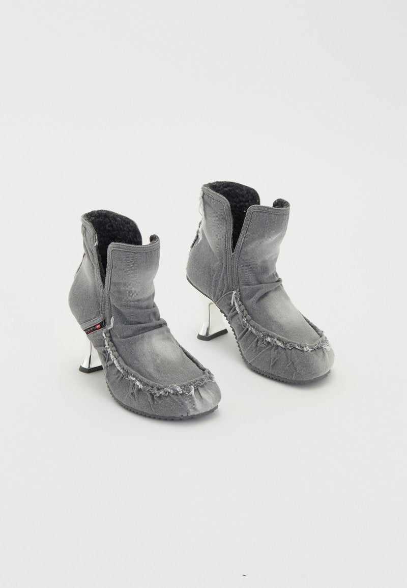 Graue Denim-Ankle-Boots mit fransigem Rand, schwarzem Fleece-Futter und glänzenden silbernen Absätzen. Einzigartiges Design mit gefaltetem Kragen und strukturierten Oberflächen.