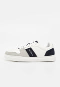 Weißer Sneaker mit niedrigem Schaft, grauen und marineblauen Wildlederakzenten, weißen Schnürsenkeln und einem schwarzen Seitenstreifen mit kleinem weißen Text.