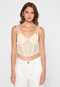 Beige Ripp-Bralette mit transparenter Strickdetails, verstellbaren Trägern und strukturierter Passform, kombiniert mit hochgeschnittenen weißen Hosen.