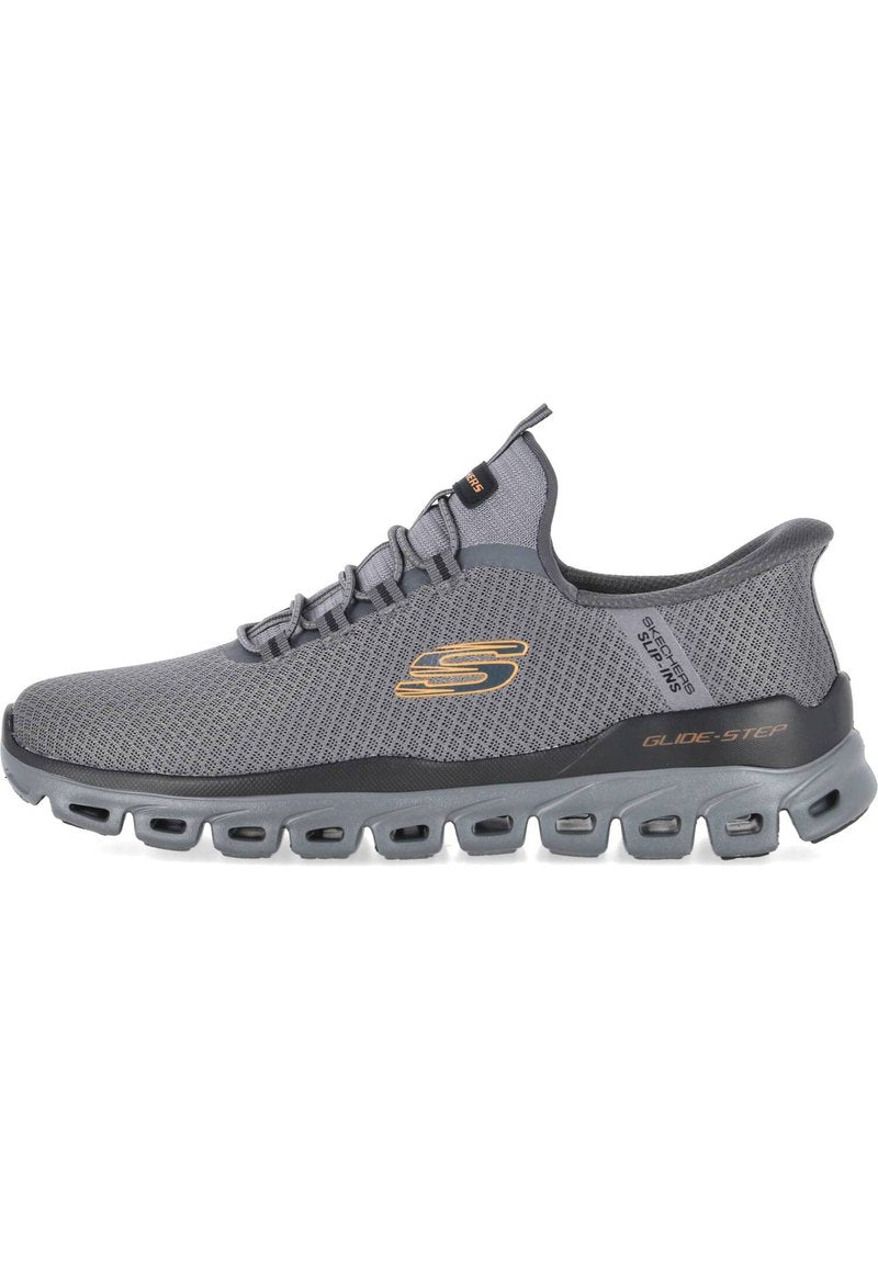 Grauer Sportschuh mit Mesh-Obermaterial, strukturierter Oberfläche, Schnürverschluss und kontrastierendem goldfarbenem Logo. Gepolsterte Sohle mit Luftkammern für zusätzliche Unterstützung.