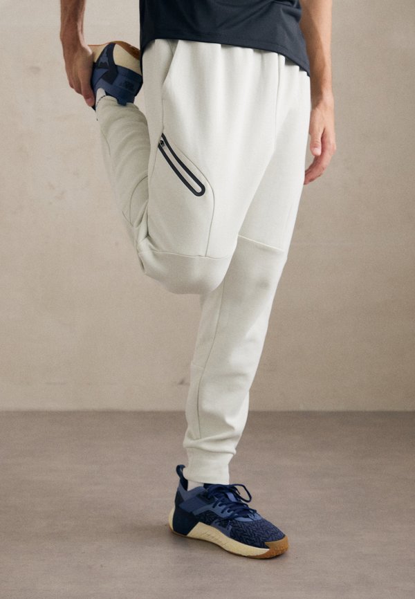 Under Armour UNSTOPPABLE FLEECE - Tracksuit bottoms - summit white/black