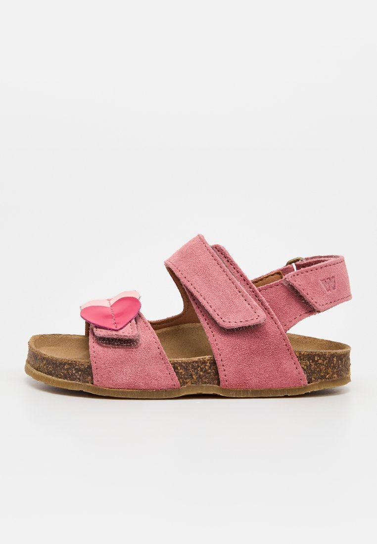 Rosa Wildleder-Kindersandale mit Korksohle, verstellbaren Klettverschlüssen und einem dekorativen pinkfarbenen Herz am vorderen Riemen.
