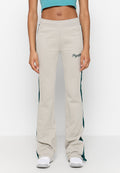 Beige Sweatpants mit slim fit, ausgestattet mit grünen Seitenstreifen und dem gestickten "Pegador"-Logo auf der linken Hüfte. Weiche Stofftextur.