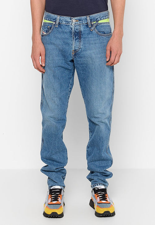 Hellblaue Jeans im lässigen Schnitt, mit kontrastierenden gelben Akzenten an den Taschen und einem klassischen Knopfverschluss.