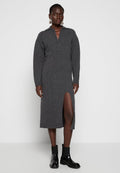 Graues gestricktes Kleid mit Kragen und langen Ärmeln, das einen schlitz bis zum Oberschenkel aufweist. Kombiniert mit schwarzen Knöchelstiefeln und strukturierten Strümpfen.