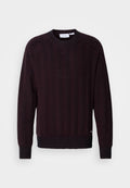 Dunkelmaroon gestrickter Pullover mit einem strukturierten Fischgrätenmuster, rundem Ausschnitt und gerippten Bündchen sowie Saum. Subtiler Logo-Detail am unteren Rand.