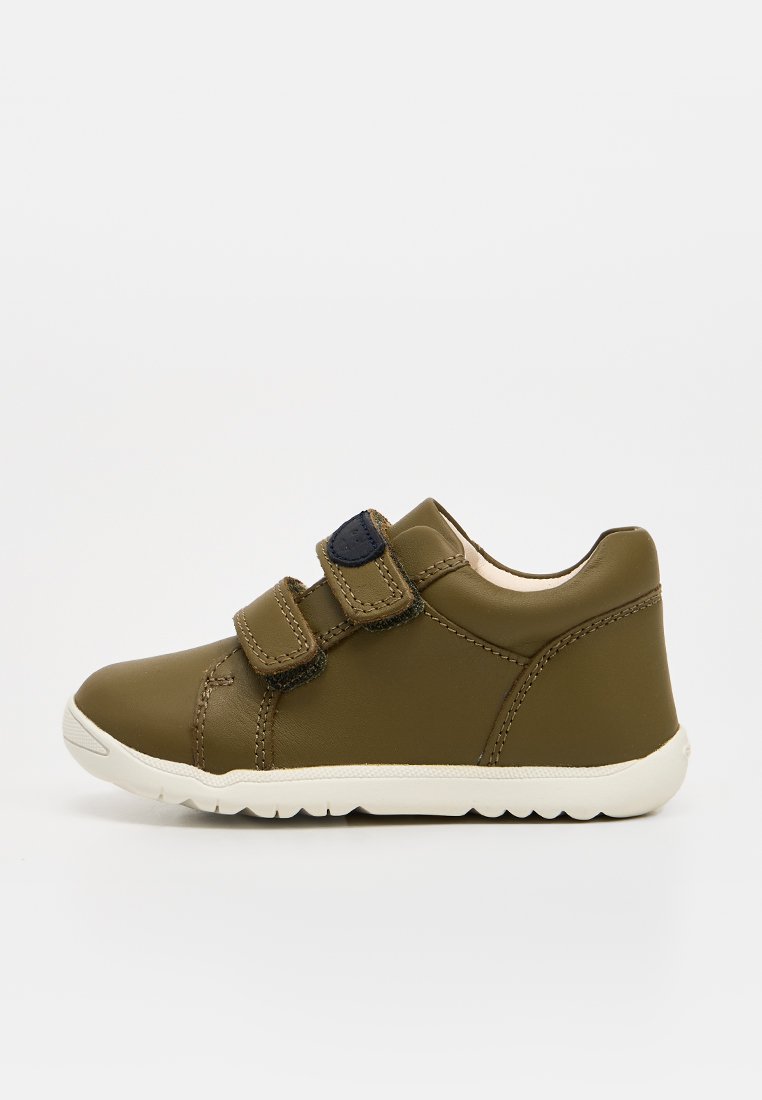 Olivgrüner Kindersneaker mit zwei verstellbaren Klettverschlüssen und einer weißen Gummisohle, seitlich auf weißem Hintergrund dargestellt.