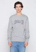 Grauer Langarm-Sweatshirt mit dem Schriftzug "Schott N.Y.C" in Blau und Rot. Verfügt über einen runden Ausschnitt und gerippte Bündchen. Hergestellt aus einem Baumwollmischgewebe.